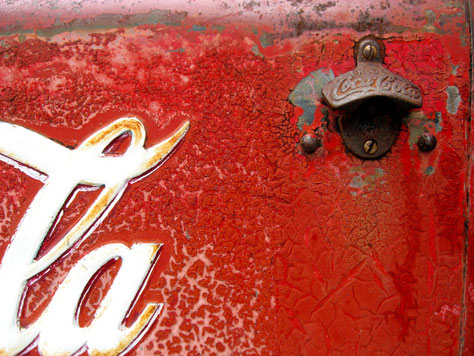 Photo Credit: David July — Bottle opener on the front of a vintage Coca-Cola metal ice box at the Frost Bites Airstream trailer, 2235 East County Highway 30A, Seaside, Florida, 26 November 2010
