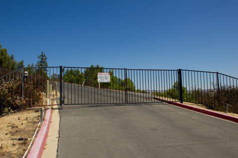 Photo Credit: David July — Gate and driveway to a water tank in far end of the parking lot of 400 National Way (1984), the fictional PlayTronics headquarters building in 'Sneakers' (1992), Simi Valley, California: 22 August 2013