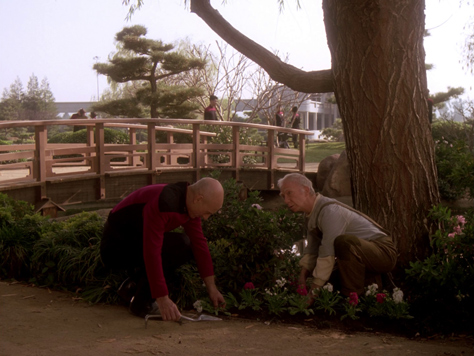 Photo Credit: CBS Television — Captain Jean-Luc Picard and groundskeeper Boothby tending a flower bed at Starfleet Academy in San Francisco