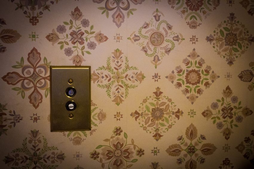 An old-style push-button light switch and floral pattern wallpaper in the kitchen of the Wickersham House (1904) museum in Pioneer Park.
