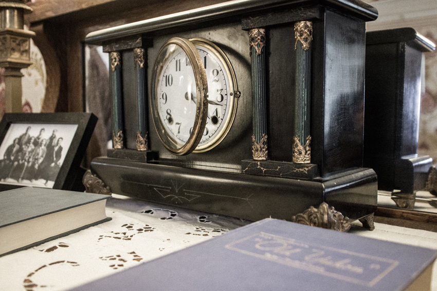 A clock, framed photograph and two books on a dresser in the front room of the Wickersham House (1904) museum in Pioneer Park.