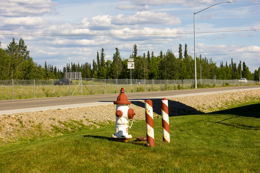 Fire hydrant and protection bollards painted in a red and white candy cane motif on Saint Nicholas Drive parallel to the Richardson Expressway (AK 2)