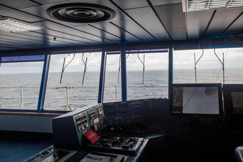 The captain's station with stabilizer, communication and navigational controls and the forward view on the Bridge on Deck 9 during an All Access Tour of the MS Empress of the Seas