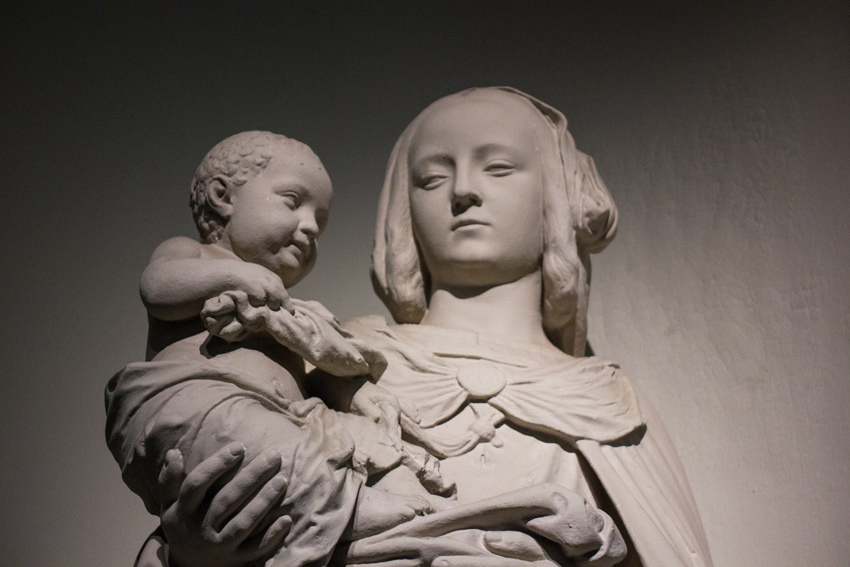 Statue of a woman holding an infant on display in the Great Hall of the College of Fine Arts Building (1916) at Carnegie Mellon University