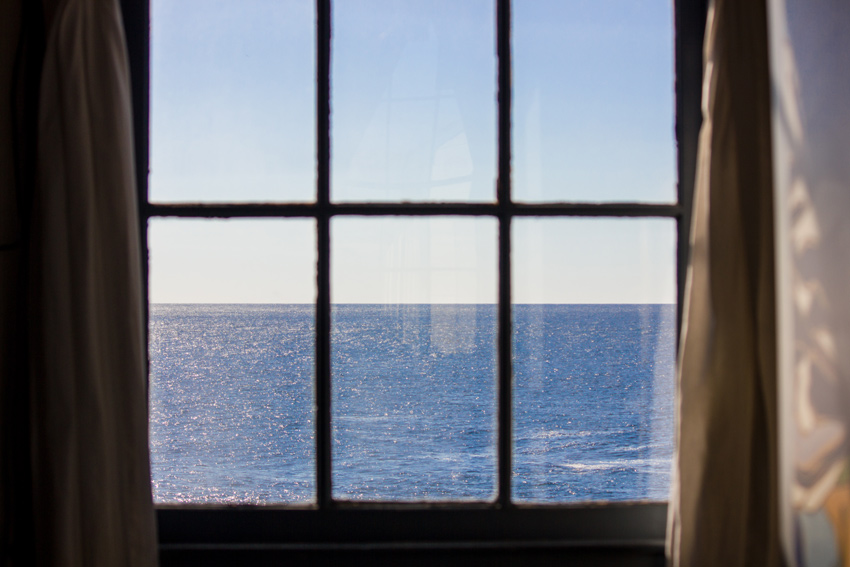 The Pacific Ocean and sky visible through a window in the fog signal building at Pigeon Point Lighthouse (1871)